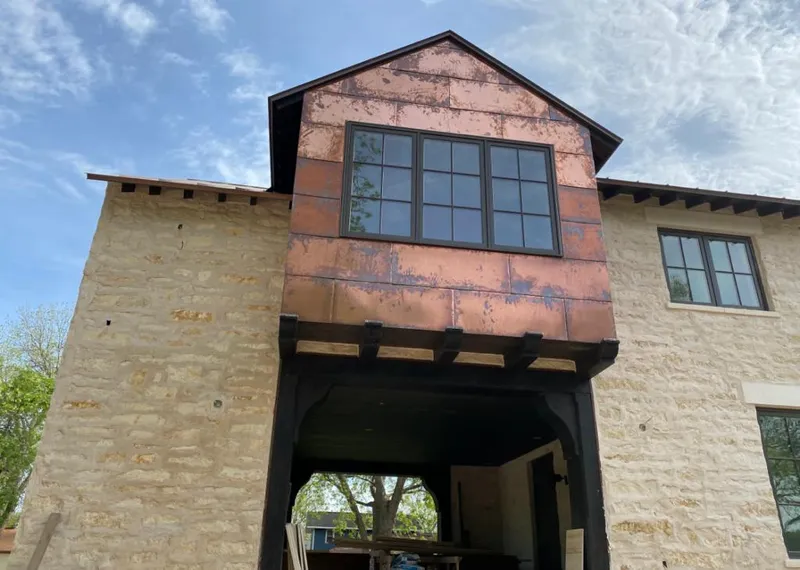 Copper metal panel facade on a stone building for Skylight Installation in Gretna