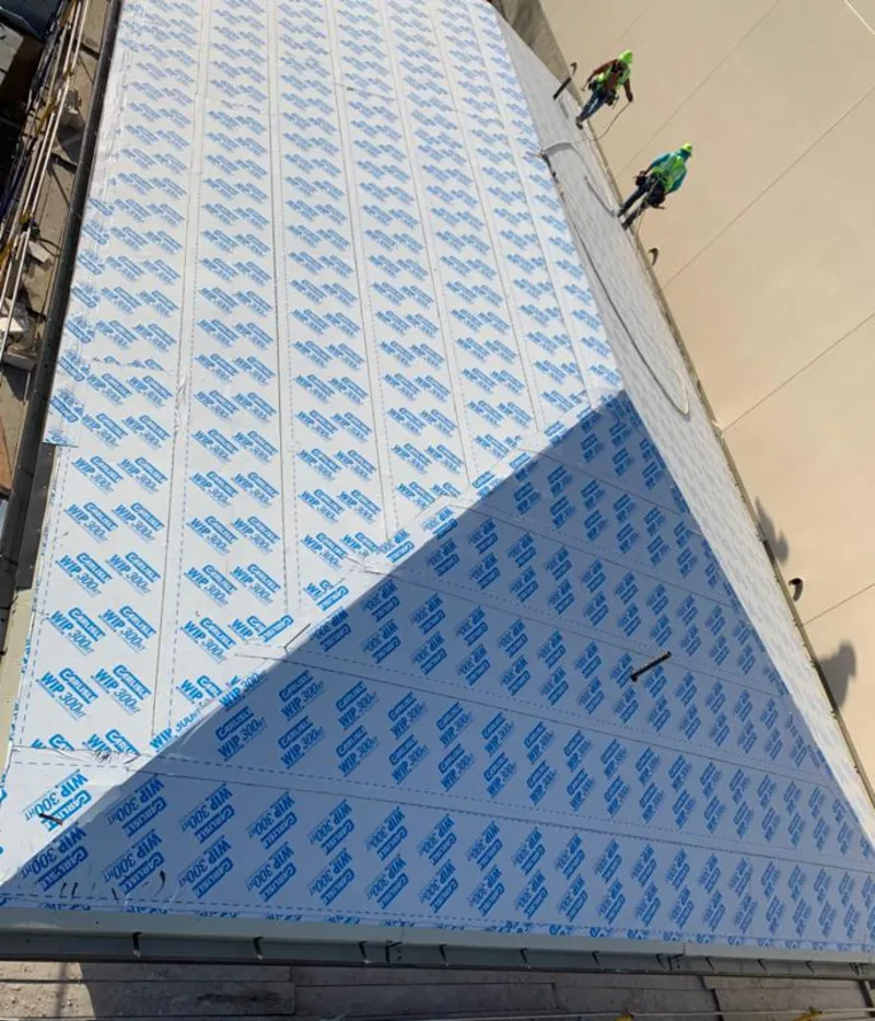 Professional roofers installing underlayment on a metal roof in Gretna